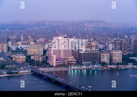 Egypt, Cairo, River Nile, Qasr El Nil Bridge and surrounding downtown buildings at dusk Stock Photo