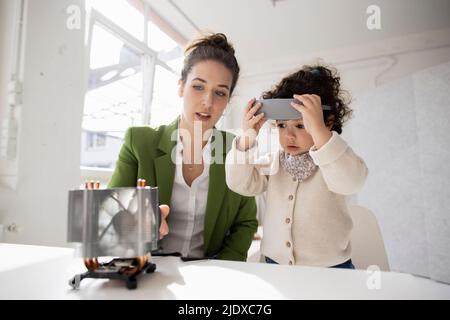 Mother and daughter exploring high-tech development the metaverse using virtual reality simulator Stock Photo