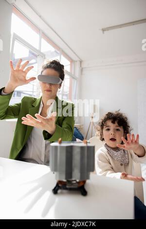 Mother and daughter exploring high-tech development the metaverse using virtual reality simulator Stock Photo