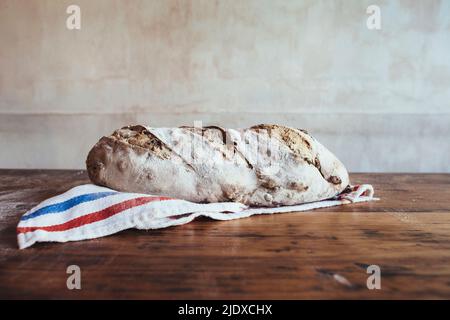Freshly baked country bread on napkin in bakery Stock Photo
