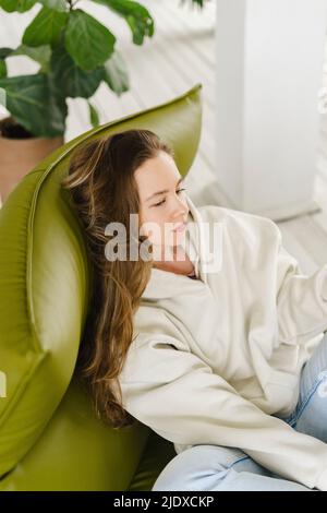 Thoughtful woman resting on couch at home Stock Photo