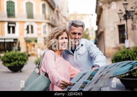 Mature couple reading map in city Stock Photo