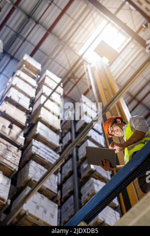 Smiling worker using tablet PC in warehouse Stock Photo