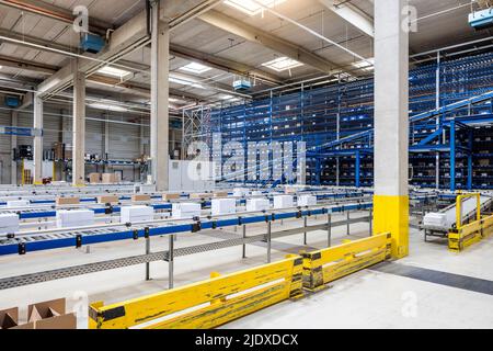 Cardboard boxes on conveyor belt in warehouse Stock Photo