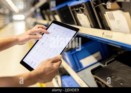 Hands of worker using tablet PC for checking inventory in warehouse Stock Photo