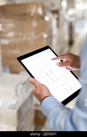 Hands of manager checking inventory through tablet PC in warehouse Stock Photo