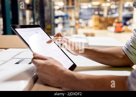 Hands of worker using tablet PC for checking inventory working in warehouse Stock Photo