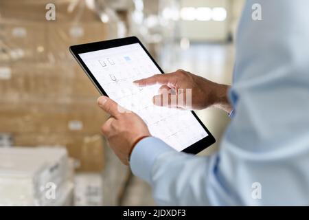 Hands of manager using tablet PC for checking inventory in warehouse Stock Photo