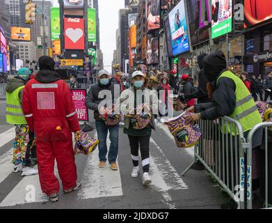 NEW YORK, N.Y. – December 31, 2021: New Year’s Eve revelers arrive at a viewing location in Times Square. Stock Photo