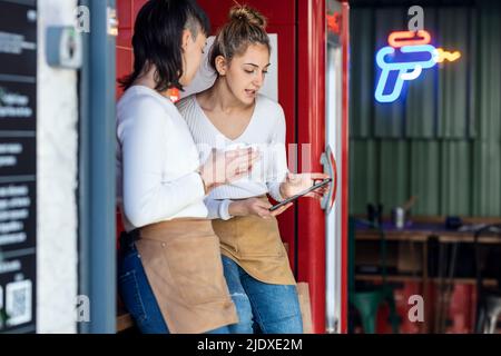Young restaurant owners discussing over tablet PC Stock Photo