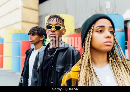 Young man wearing sunglasses standing with friends Stock Photo