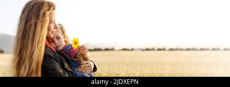 Portrait of a happy young mother and her lovely daughter playing and laughing in a field of wheat . Freedom concept. Banner,copy space for mothers day. Stock Photo