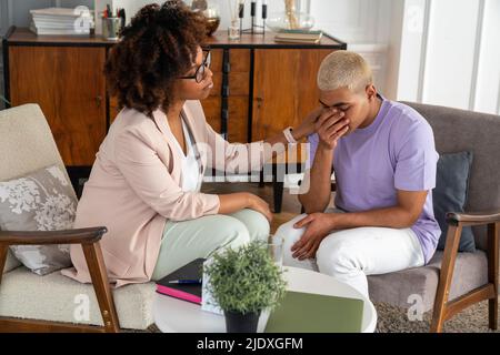 Young psychologist consoling crying patient at office Stock Photo