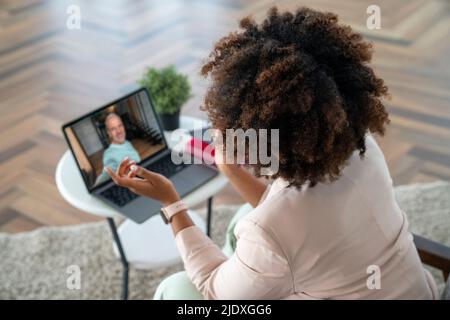 Young woman on video call with man in office Stock Photo