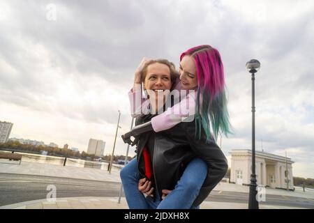 Happy young man giving piggyback ride to girlfriend with amputated hand Stock Photo