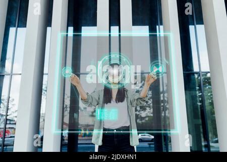 Woman wearing VR glasses touching virtual screen in front of column Stock Photo