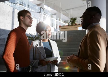 Businessman discussing with colleagues in modern office Stock Photo
