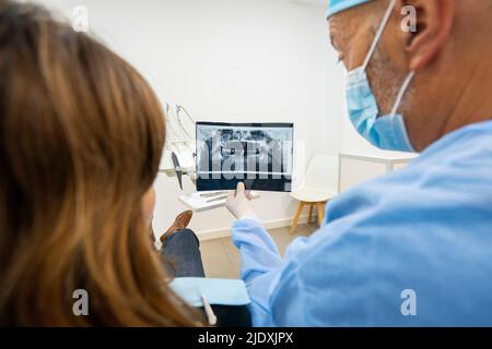 Dentist showing x-ray to patient at clinic Stock Photo