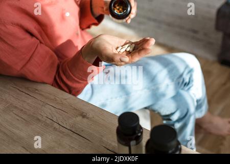 Woman pouring pills into her hand Stock Photo