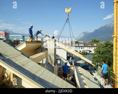 Blue-collar workers at construction site standing on rooftop Stock Photo
