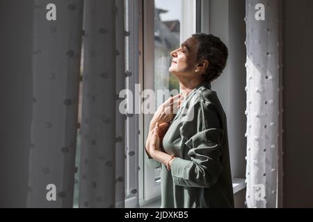 Mature woman with short grey hair at home Stock Photo