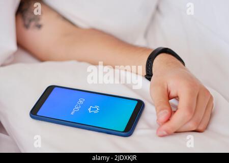 Hands of man by mobile phone showing alarm on smart phone Stock Photo
