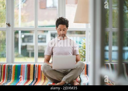 Mature man using laptop at home Stock Photo