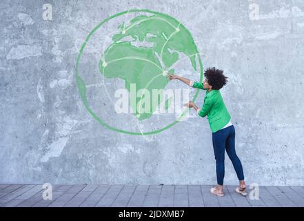 Woman looking at painted globe with communication network Stock Photo