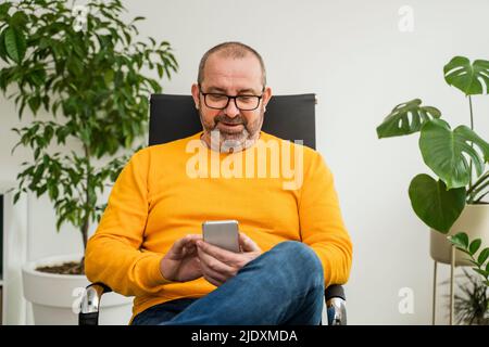 Businessman text messaging on smart phone at office Stock Photo