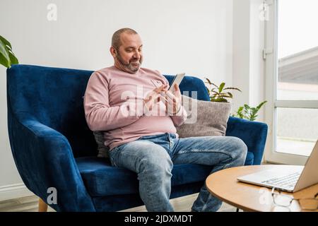 Smiling freelancer using smart phone at home Stock Photo