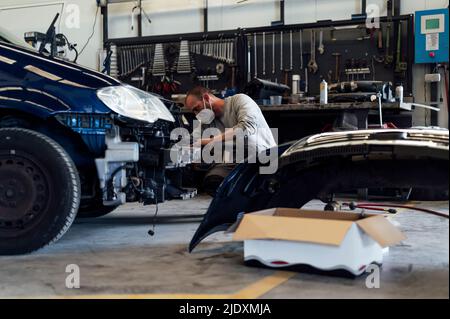 Mechanic working in auto repair shop Stock Photo
