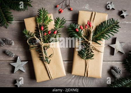 Studio shot of naturally wrapped Christmas presents decorated with spruce twigs Stock Photo