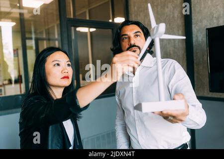 Business people analyzing wind turbine model at office Stock Photo