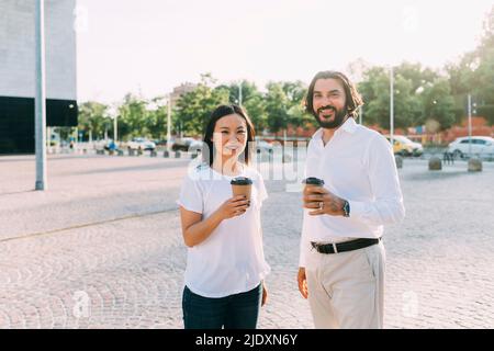 Business colleagues having coffee on footpath in city Stock Photo