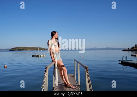 https://l450v.alamy.com/450v/2jdxne5/smiling-woman-standing-on-jetty-over-lake-2jdxne5.jpg