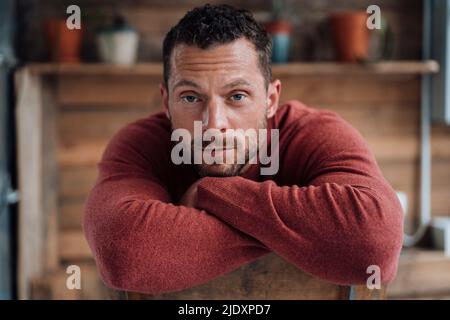 Mature man with head resting on arms Stock Photo