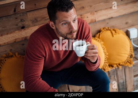 Man having coffee sitting on bench Stock Photo