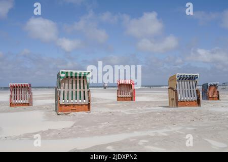 Germany, Lower Saxony, Juist, Hooded beach chairs on empty beach Stock Photo