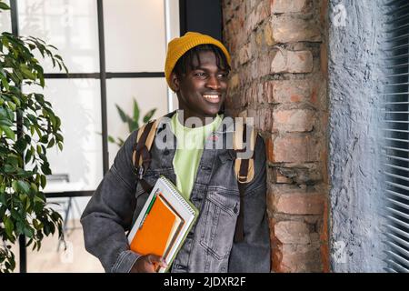 Smiling student looking through window at home Stock Photo