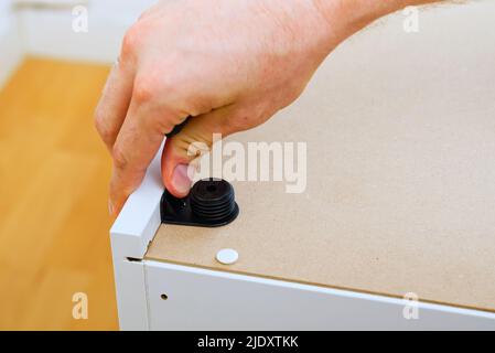 Professional Furniture Assembly Worker Assembles Shelf. Furniture assembly process. DIY Assembling Stock Photo
