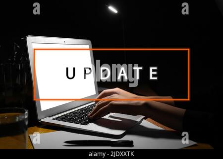 Woman working on laptop at night. Update concept Stock Photo