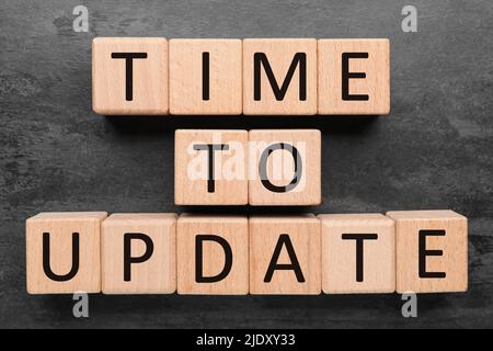 Text TIME TO UPDATE made of wooden cubes on dark background Stock Photo