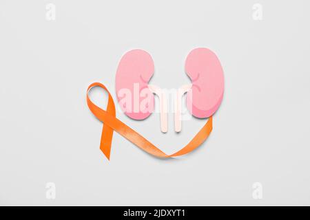 Orange awareness ribbon and paper kidneys on grey background Stock Photo