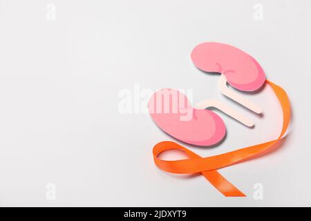 Orange awareness ribbon and paper kidneys on grey background Stock Photo