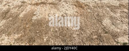 cracked ground texture of brown soil. clay background with cracks. panoramic image. Stock Photo