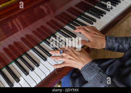 Close-up, hands of an old woman playing the piano Stock Photo