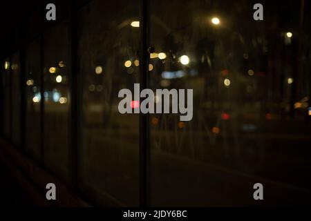 Lights on road at night. Blurred background through glass in dark. Stock Photo