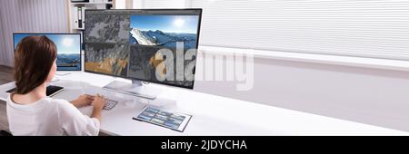 Rear View Of A Woman Working On 3D Landscape On Computer In Office Stock Photo
