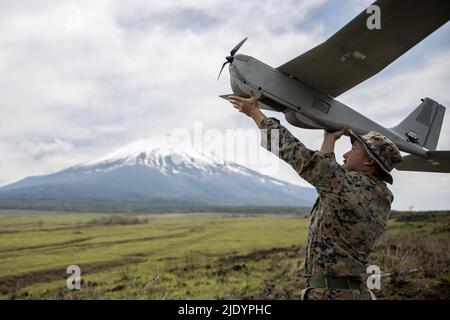 Camp Fuji, Japan. 11th May, 2022. U.S. Marine Corps Cpl. Daniel Enders, a rifleman with 1st Battalion, 3rd Marines, 3rd Marine Division, launches an RQ-20 Puma during Mission Rehearsal Littoral Exercise 2022 at Combined Arms Training Center, Camp Fuji, Japan, May 11, 2022. The purpose of the MRLEX is to conduct an airfield survey of an existing Aircraft Landing Zone for infrastructure improvement, runway repair and preparation of potential forward arming and refueling points, in cooperation with our Japanese allies while advancing III Marine Expeditionary Forces and Marine Corps Installations Stock Photo