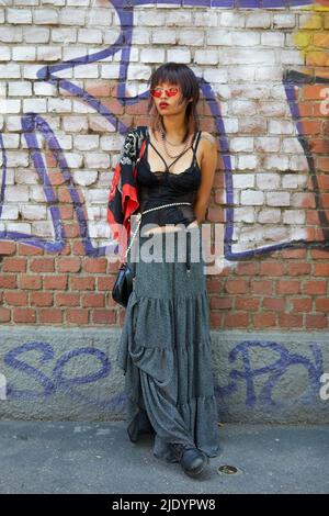 MILAN - JUNE 18: Woman with Fendi shirt and bag and golden Clou